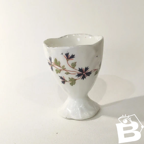 1 Coquetier ancien sur piédouche en porcelaine, décor aux barbeaux