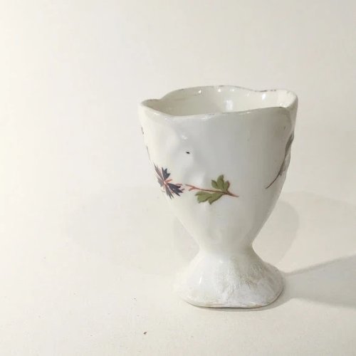 1 Coquetier ancien sur piédouche en porcelaine, décor aux barbeaux
