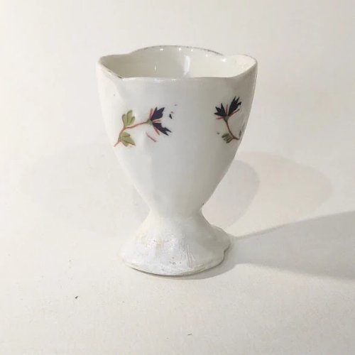 1 Coquetier ancien sur piédouche en porcelaine, décor aux barbeaux