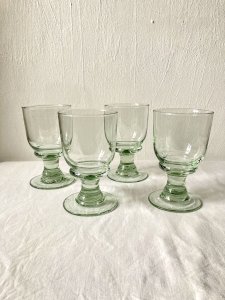 4 stemmed glasses made of handcrafted blown glass in green hue.
