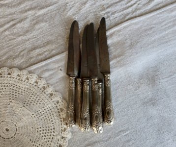 6 antique metal knives with handles decorated with cartouches and scrolls.