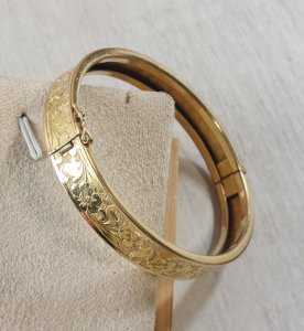 Vintage gold-tone metal bangle bracelet with flower design.