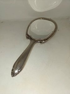 ancien miroir à main en metal argente arriere travaillé en bon etat