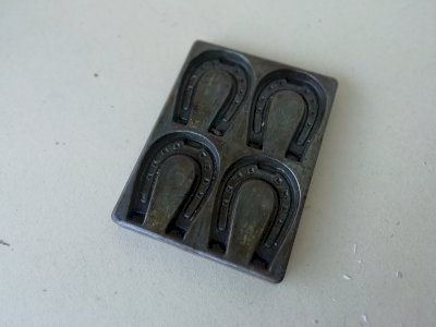 old cast iron chocolate mold in the shape of a horseshoe