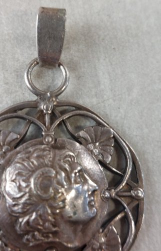 Ancien pendentif décor tête, en argent ^