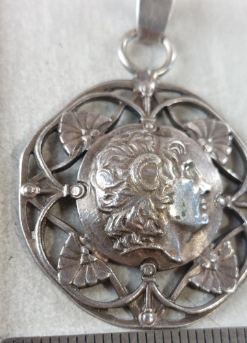 Ancien pendentif décor tête, en argent ^
