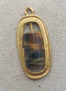 Ancient pendant, tiger's eye stone, in gilded metal.
