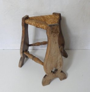 old wooden and straw tripod stool