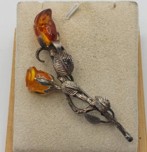 Ancient beautiful brooch, made of solid silver and amber, rose-shaped.