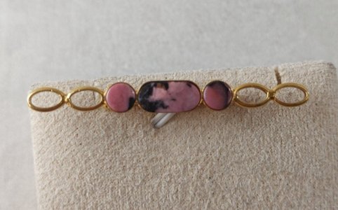 Vintage gold-tone metal brooch, adorned with pink stone.