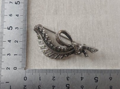 Vintage feather-shaped brooch in silver and rhinestones.