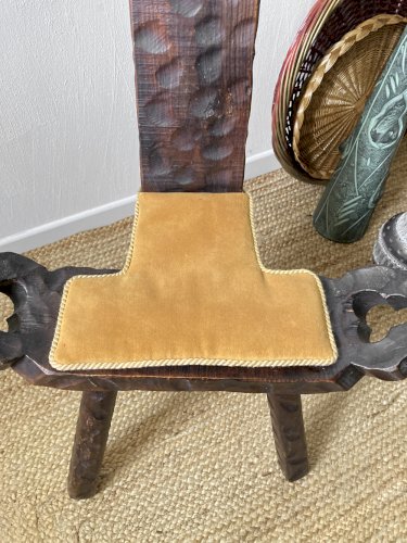 Ancienne chaise tripode en bois sculpté, coussin velours moutarde