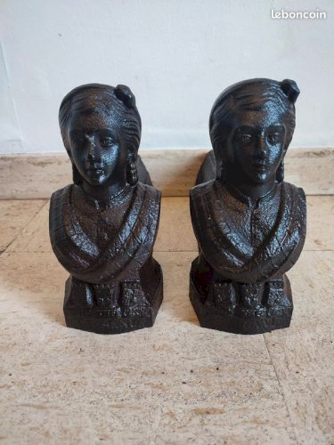 Ancienne paire de chenets en fonte datant du 19 eme siecle avec visage feminin et armoiries en bon etat