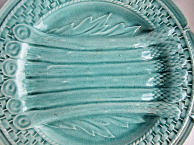 Assiette en barbotine non signée: Asperges et feuilles d'artichaut sur fond bleu