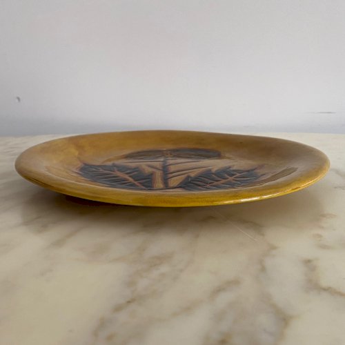 Assiette en terre cuite par Jean Lurçat décor de feuillage sur fond jaune M3760