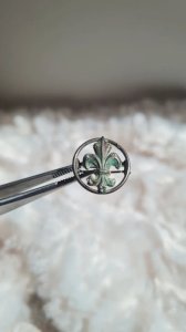 Old flowing jewel transitioning from a silver fleur-de-lis necklace