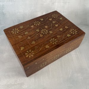 Wooden box with brass and copper inlay, decorated with flowers and foliage.
