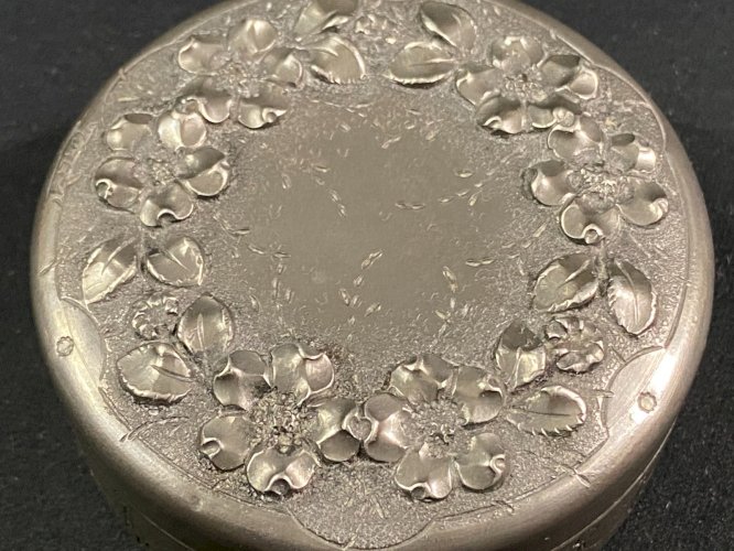 Boite couverte circulaire signée en étain à décor floral en relief début XXe