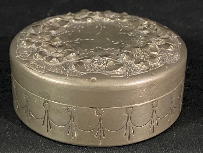 Boite couverte circulaire signée en étain à décor floral en relief début XXe