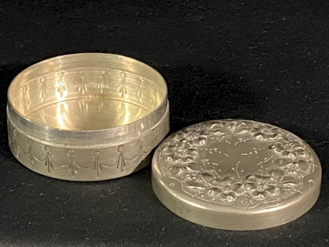 Boite couverte circulaire signée en étain à décor floral en relief début XXe
