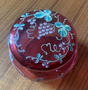 Red enamelled glass candy jar with vine and grape cluster decoration from the 1900s.