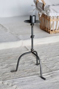 Antique three-legged metal candlestick with knot decoration