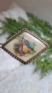 Antique brooch depicting a scene of two lovers.