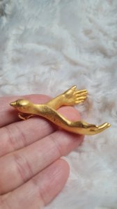 Bronze-gilded artist brooch with hands-shaped wings (Menouha)