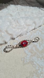 Broche vintage avec un strass rouge