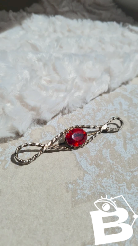 Broche vintage avec un strass rouge