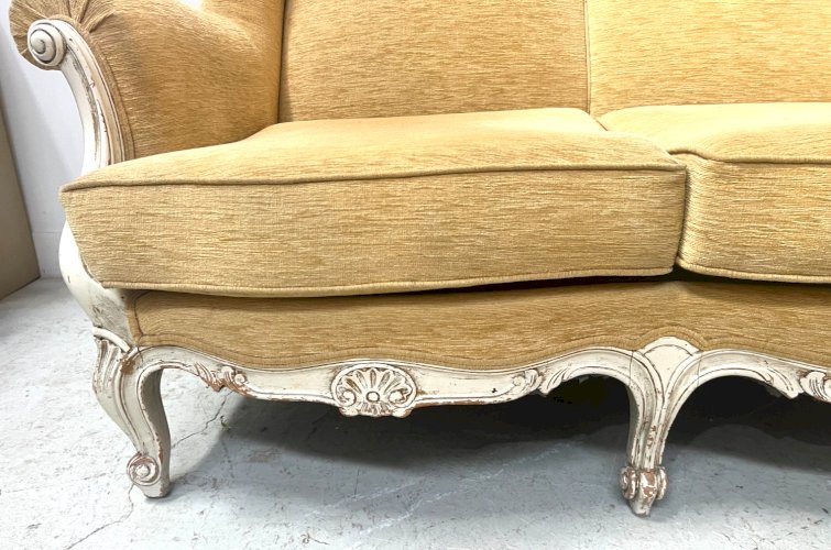 Canapé trois places a oreilles de style Louis XV en hetre patiné XX siècle