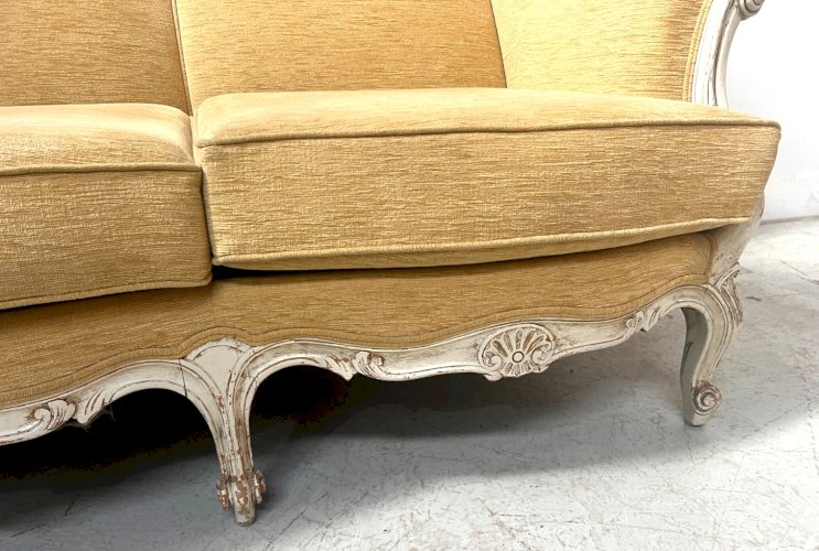 Canapé trois places a oreilles de style Louis XV en hetre patiné XX siècle