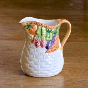 Relief earthenware carafe with hand-painted vegetable basket.