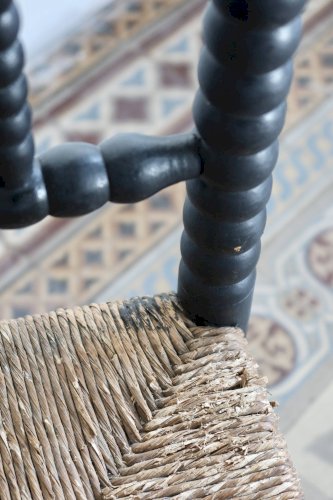 Chaise d’angle ancienne en bois tourné noir et assise en paille