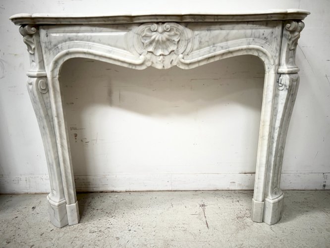 Cheminée de style Louis XV en marbre blanc veiné XX siècle