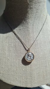 antique brass and aluminum necklace and pendant of Saint Christopher and an angel