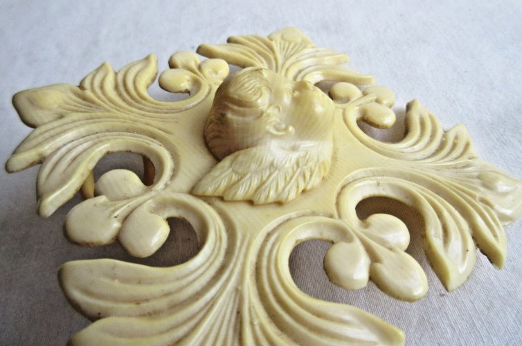 Croix de berceau Art Déco en bakélite beige: Angelot sur acanthes et baies