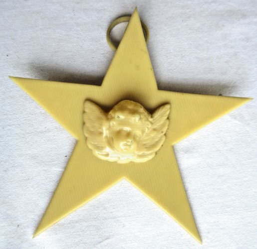 Croix de berceau Art Déco en bakélite beige: Angelot sur étoile à suspendre