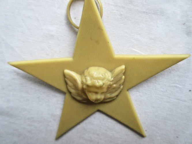 Croix de berceau Art Déco en bakélite beige: Angelot sur étoile à suspendre