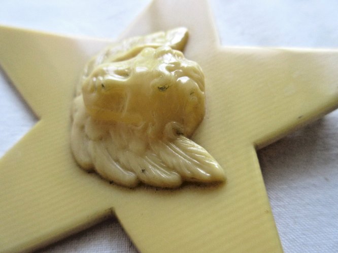 Croix de berceau Art Déco en bakélite beige: Angelot sur étoile à suspendre