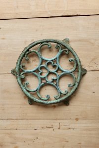Vintage round turquoise perforated cast iron trivet