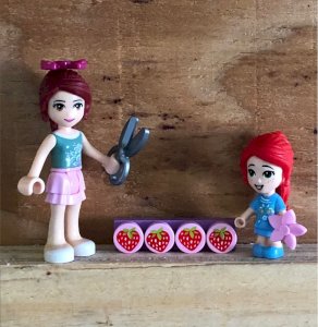 Lego Friends figurines are picking strawberries.