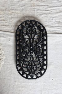 Large vintage black cast iron oval trivet - Cut-out decoration