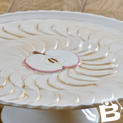 Grand plat à tarte vintage sur piédouche en barbotine tarte aux pommes