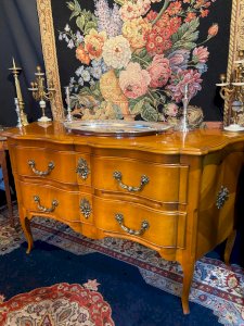 Grande commode sauteuse à façade arbalète merisier blond ornement bronze soleil