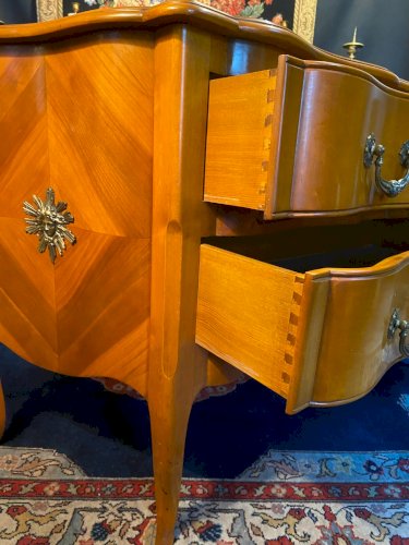 Grande commode sauteuse à façade arbalète merisier blond ornement bronze soleil