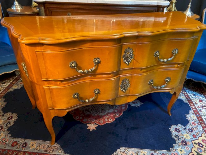 Grande commode sauteuse à façade arbalète merisier blond ornement bronze soleil