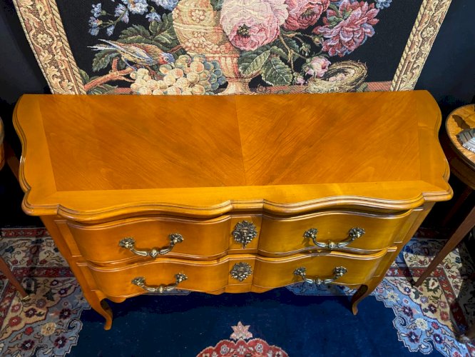 Grande commode sauteuse à façade arbalète merisier blond ornement bronze soleil