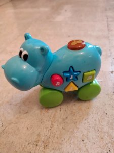 Musical push-pull toy in the shape of a hippopotamus in good condition.