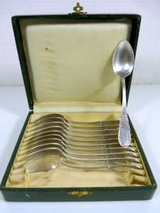 Set of 11 small white metal sculpted spoons in the Louis XVI style with stamps in a box.